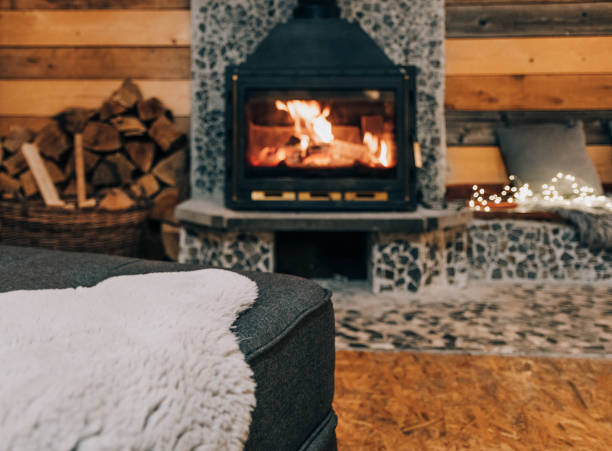istock Selective focus shot of a fluffy blanket on a sofa with a fireplace in the background 1440292093