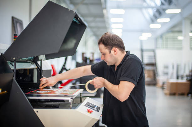 istock Experienced operator works on a UV printer in printing house 1440292479