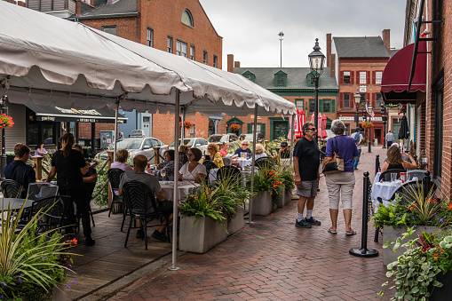 Newburyport, MA, US - September 13, 2022: Street scene in downtown of this small town with its quaint streets with 19th century brick buildings and trendy shops and restaurants.