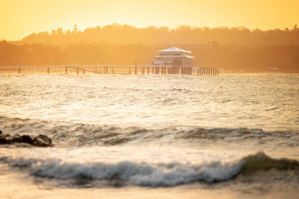 Pier with tea house in Timmendorf on a hazy day at sunset.