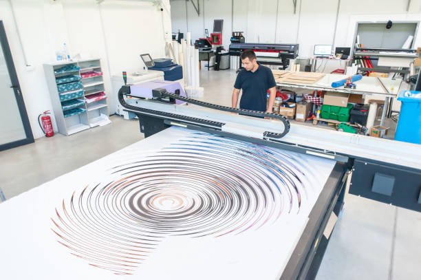 istock Experienced operator works on a UV printer in printing house 1440295786