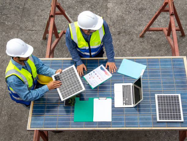 istock Two technician discussing the plan with solar photovoltaic panels at the workplace, sustainable development concept 1440296214