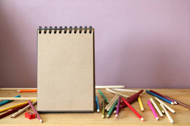 istock an empty open notebook made of brown paper and colored pencils. education, school background. scene creator, mockup, space for text. 1440297008