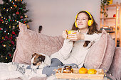 a teenage girl with headphones is sitting on the couch, resting
