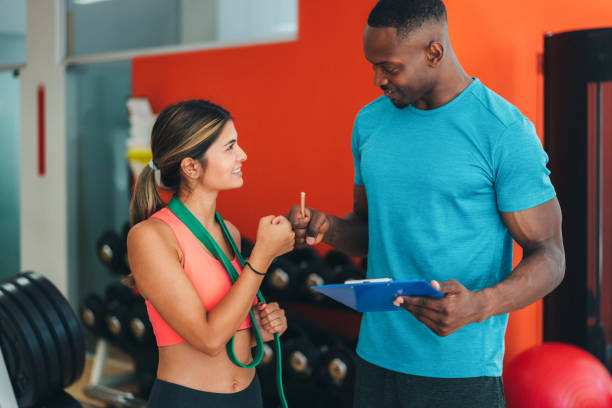 Sports training in the gym with personal trainer Personal trainer greeting his client with fist bump after successful workout personal trainer stock pictures, royalty-free photos & images