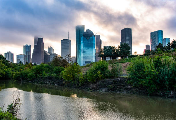 Houston skyline from Buffalo Bayou The skyline of Houston, Texas at daybreak under a dramatic sky. robert michaud stock pictures, royalty-free photos & images