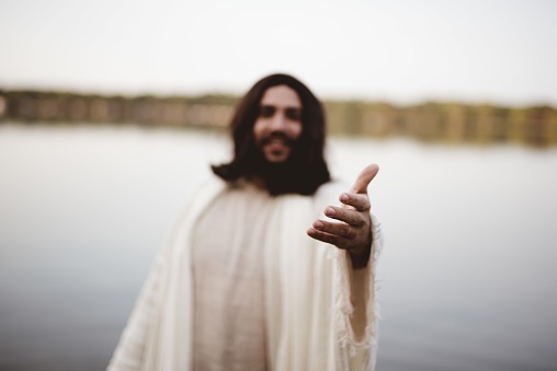 The Jesus Christ lending a helping hand with a blurred background