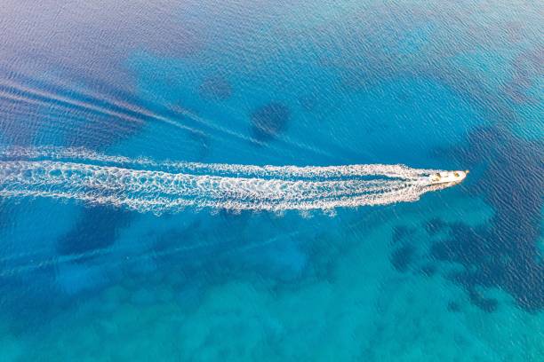 Beautiful high angle shot of a ship engine trail in the ocean A beautiful high angle shot of a ship engine trail in the ocean thrust stock pictures, royalty-free photos & images