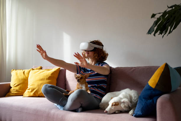 istock young ginger woman relaxing on sofa with VR headset and her pet 1440308587