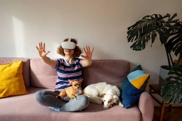 istock young ginger woman relaxing on sofa with VR headset and her pet 1440308602