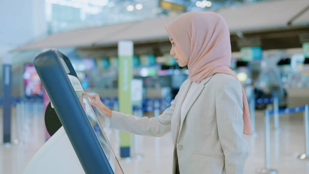 istock Muslim woman with self check-in machine 1440311352
