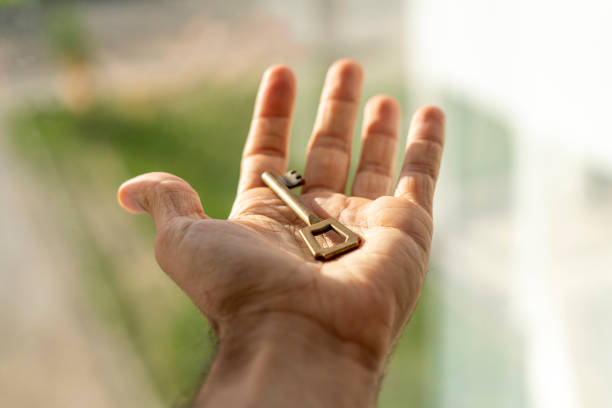 istock Key to success or happiness. Hand holding key 1440311387