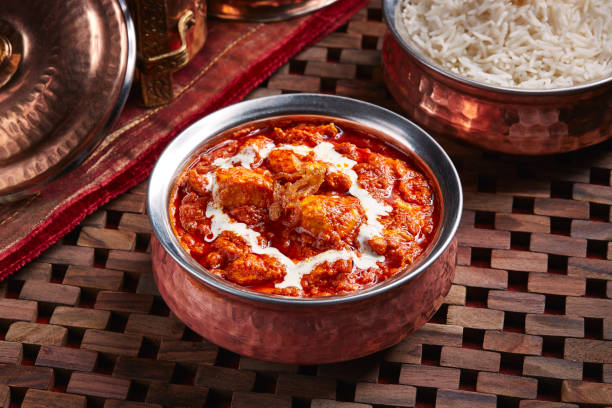 Chicken Makhani or butter chicken karahi with white rice served in dish isolated on table side view of middle east food stock photo