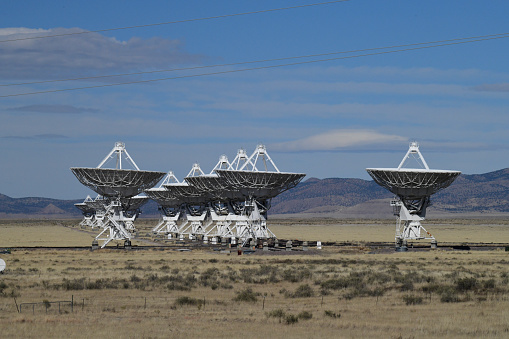 Magdelena, NM. USA-November 2, 2022: Radio Antennas from the Very Large Array. The VLA (Very Large Array) is a US Government facility located in the Desert of New Mexico.\nAstronomers use these Radio Telescopes for astronomical research.\nThe dishes can be reconfigured by relocating them along a special railroad track to change radius and density of the radio observatory.