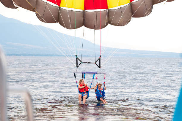 The parachute is fully inflated, showcasing vivid yellow and white colors as it glides through the air.