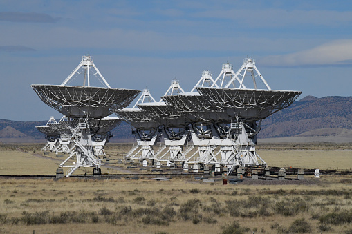 Magdelena, NM. USA-November 2, 2022: Radio Antennas from the Very Large Array. The VLA (Very Large Array) is a US Government facility located in the Desert of New Mexico.
Astronomers use these Radio Telescopes for astronomical research.
The dishes can be reconfigured by relocating them along a special railroad track to change radius and density of the radio observatory.