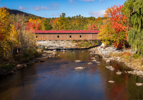 Colorful fall trees in the Adirondacks around Jay covered bridge in New York State in the autumn