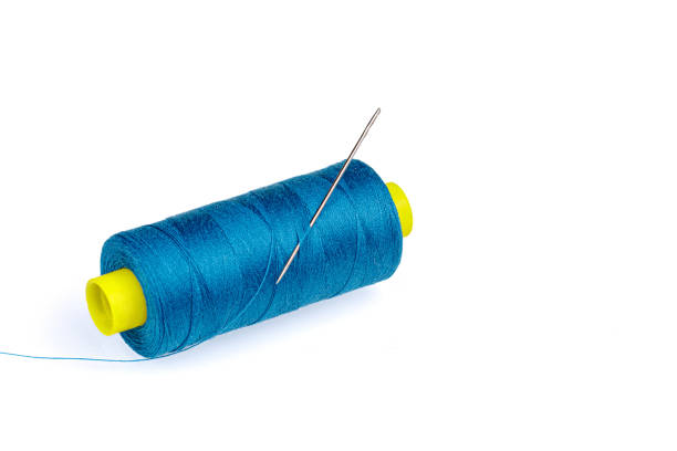 istock Macro skein of blue thread with a needle on a white background 1440317122