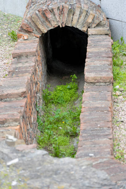 Partial image of a historical antique Roman excavation of a brick vaulted canal drain partially overgrown with grass Concept for ancient civilizations and past times