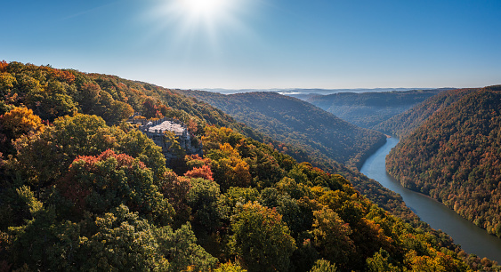 View up the Cheat River in narrow wooded gorge in the autumn with Coopers Rock overlook in the colorful trees near Morgantown, West Virginia