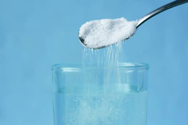 istock pouring white sugar in a glass of water on table 1440320534