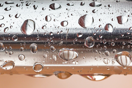 Water drops on aluminum base.  Macro photo of water drops.  Aluminum bar wet from the rain.