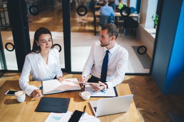 istock Confident Caucasian male and female colleagues communicating during work at desktop with digital technology, successful business partners enjoying collaboration indoors discussing financial website 1440324223