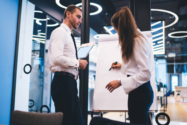 istock Professional economist using white board for writing ideas information for project during briefing with partner, successful business people collaborating together searching solutions in company 1440324225