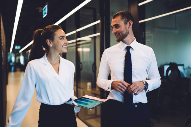 istock Successful experienced employees 30s communicating about negotiations in company hallway, cheerful male and female partners talking about cooperation strategy using digital tablet for business 1440324311