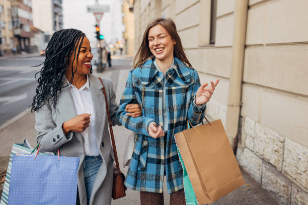 istock Two gorgeous women casually chat while walking through town after a successful shopping spree 1440327263