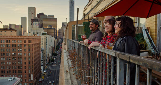 istock Friends Looking Out at Sunset on Urban Balcony 1440328004