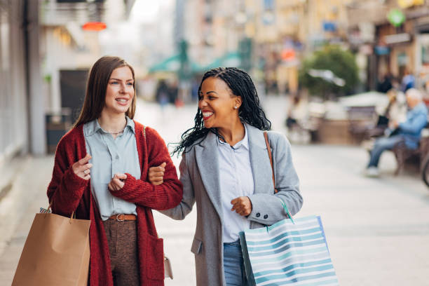 istock Two cheerful women casually chat while shopping and walking around town 1440328194