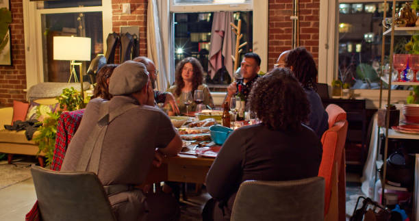 istock Diverse Group Gathered Around Dining Table Eating and Chatting at Friendsgiving Party 1440328353