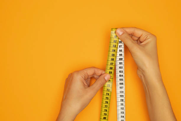 istock Woman Holding Tape Measure 1440329076