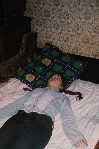 La adolescente está durmiendo en la cama. Foto casera vintage photo
