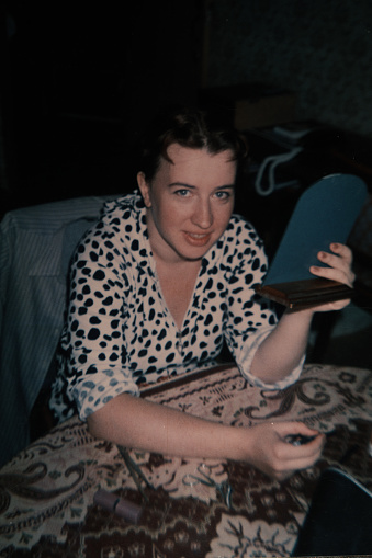 La mujer joven se está reconciliando en la mesa. Foto vintage photo