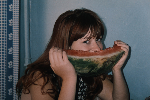 Vintage home photo of teenage girl eating watermelon