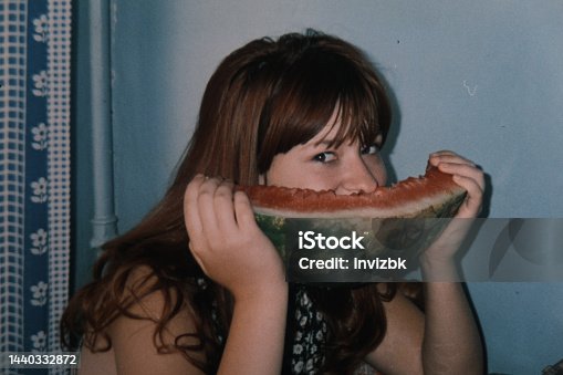 istock Vintage home photo of teenage girl eating watermelon 1440332872