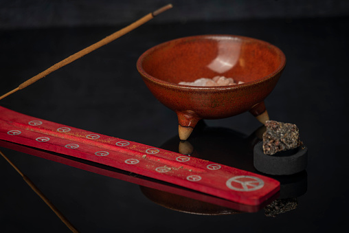 Aromatic stick and gum olibanum on shiny black table