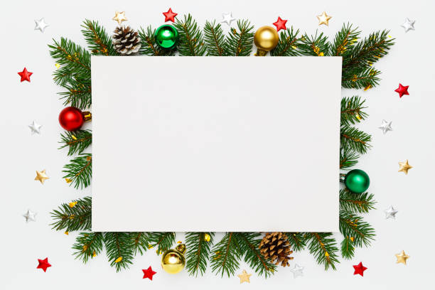 istock Christmas, New Year holiday layout with copy space for text. Blank white paper in frame of natural fir tree branches, pinecones and multicolored decorations on white flat lay background. 1440338007