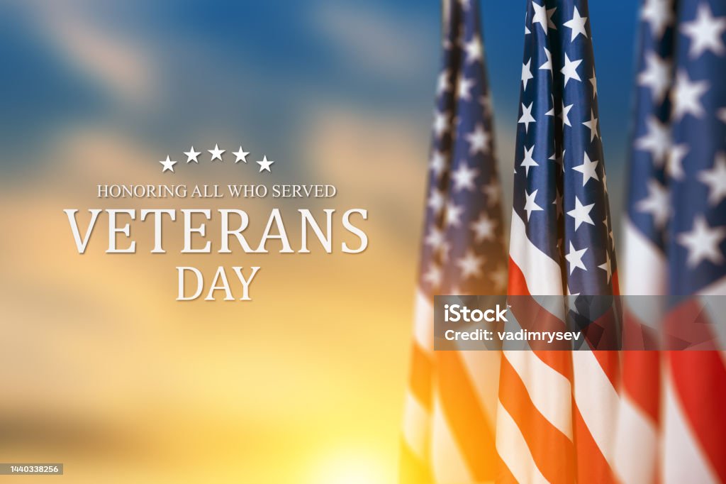 American flags with Text Veterans Day Honoring All Who Served on sunset background. American flags with Text Veterans Day Honoring All Who Served on sunset background. American holiday banner. US Veteran's Day Stock Photo