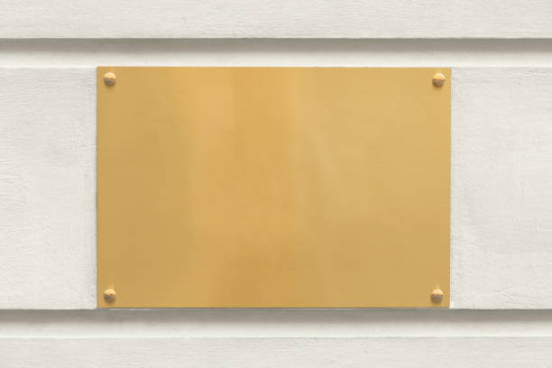 Blank golden plaque sign A blank golden sign outdoors on the wall of an office building. memorial plaque photos stock pictures, royalty-free photos & images