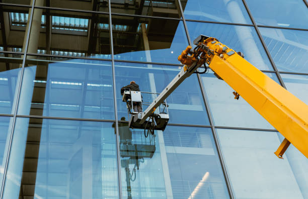 Cleaner workers using a cherry picker to clean a facade of a contemporary office building. stock photo