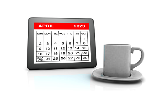 April 2023 calendar on Tablet PC and Coffee Cup