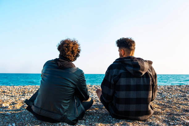 istock Two friends sitting on the beach 1440343735