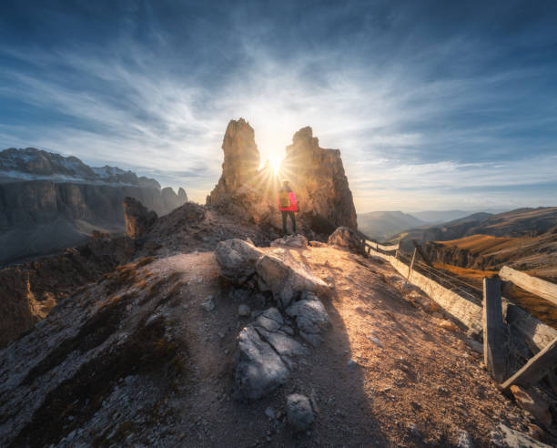 秋の夕暮れ時の山道と石の女性 - country road fence road dolomites ストックフォトと画像