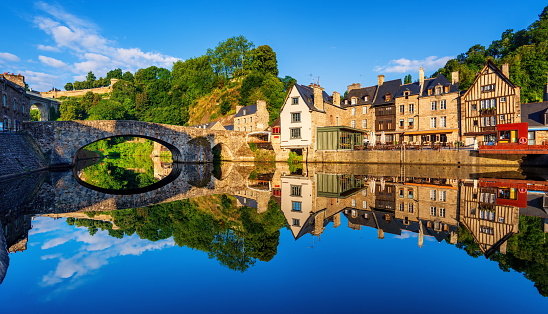 The Old stone bridge and historical medieval houses reflecting in La Rance river in Dinan town port, Brittany, France