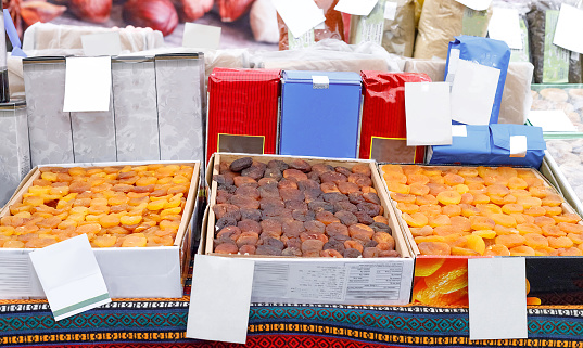 Sale of dried fruits in the street market. Counter with oriental sweets. Delicious dried apricots