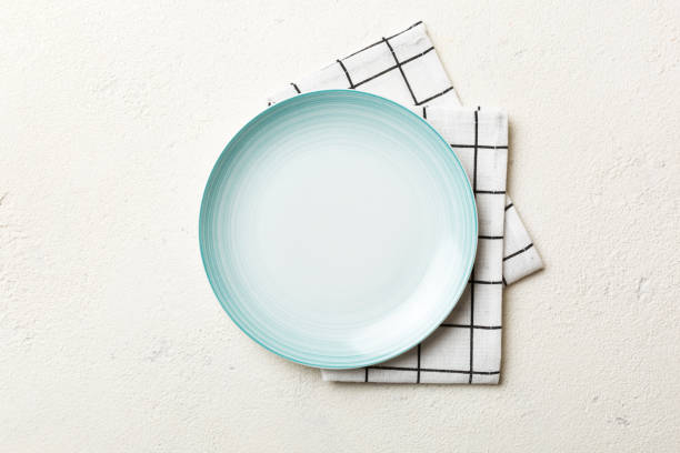 istock Top view on colored background empty round blue plate on tablecloth for food. Empty dish on napkin with space for your design 1440346142