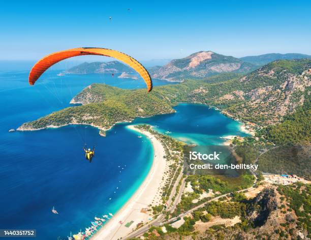 Paragliding In The Sky Paraglider Tandem Flying Over The Sea With Blue Water And Mountains In Bright Sunny Day Aerial View Of Paraglider And Blue Lagoon In Oludeniz Turkey Extreme Sport Landscape Stock Photo - Download Image Now